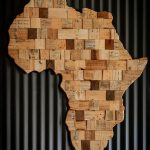 Artistic wooden map of Africa against dark corrugated background.